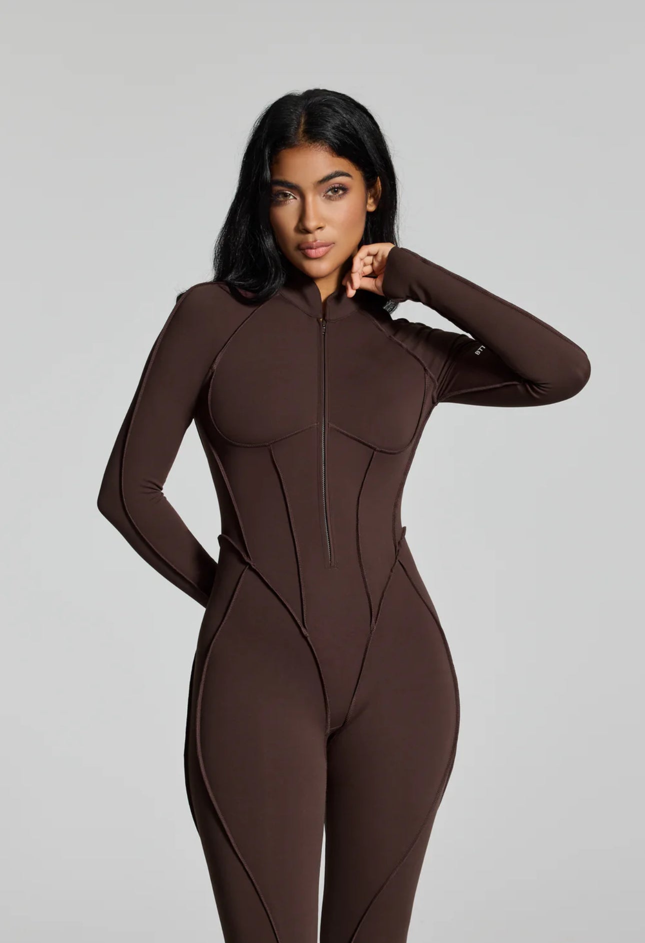 Jumpsuite EMY aderente con schiena scoperta, pensata per valorizzare la silhouette con un effetto shaping. Il tessuto elasticizzato ad alta compressione modella le forme
