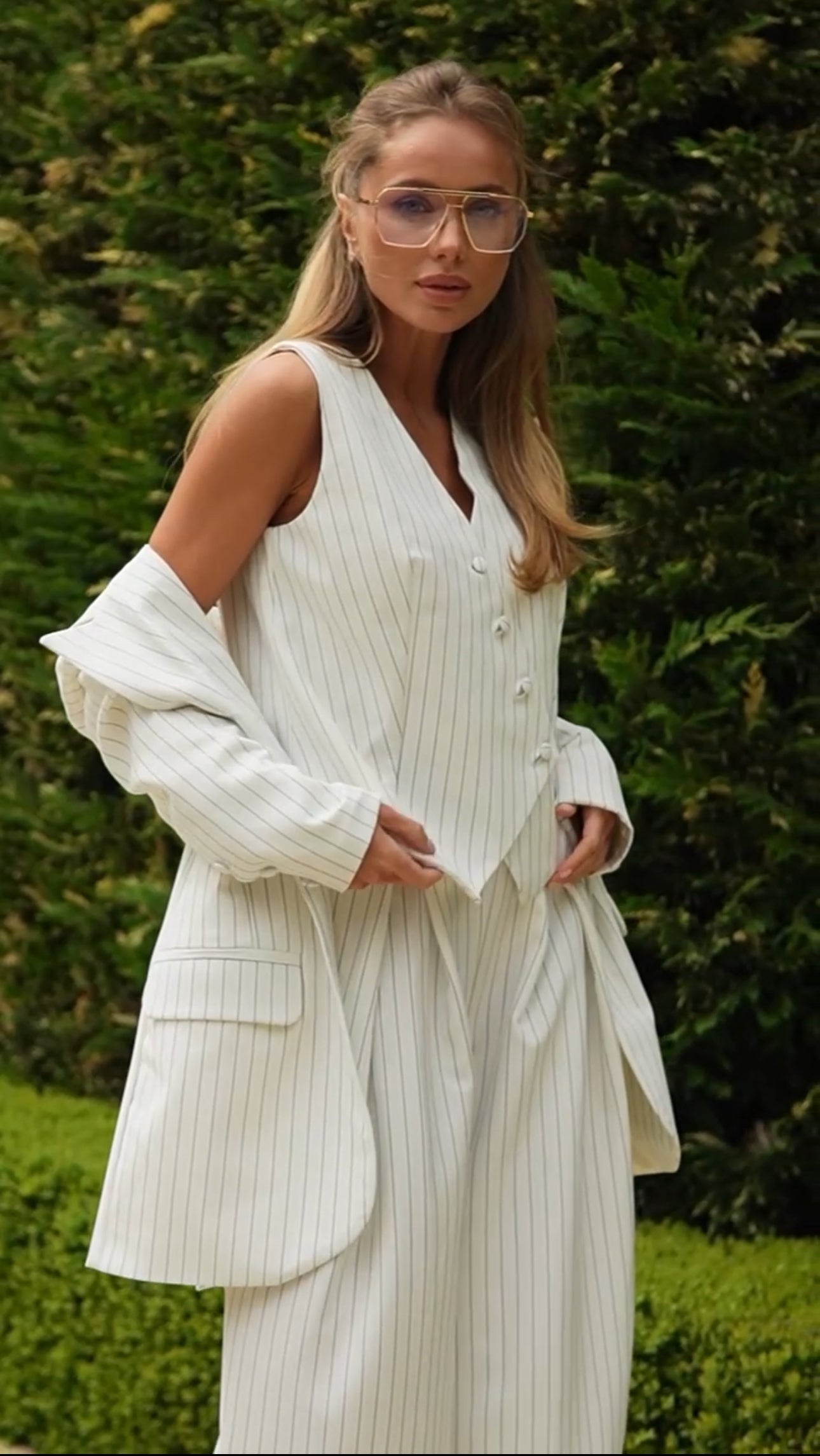 Tailleur VALERIA Blazer dal  taglio elegante e strutturato con spalle leggermente ampie, gilet con bottoni asimmetrici, pantaloni a vita alta con ampia vestibilità e pieghe, che creano un effetto fluido e raffinato.