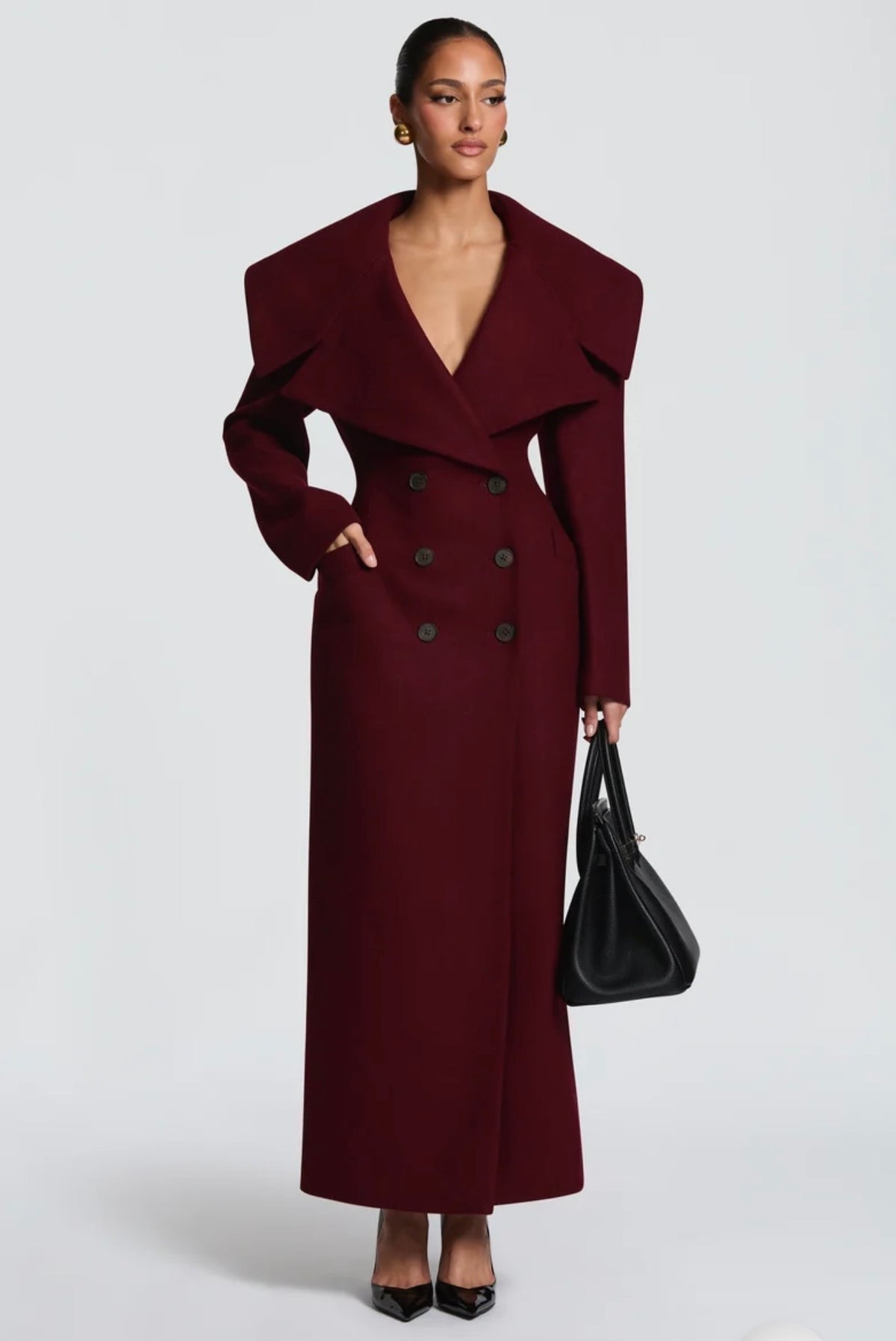Cappotto Lungo Sartoriale con Maximantellina Un capospalla scenografico e di classe che ridefinisce l'eleganza invernale. Caratterizzato da un'ampia mantellina sulle spalle e una silhouette clessidra accentuata dal punto vita segnato.