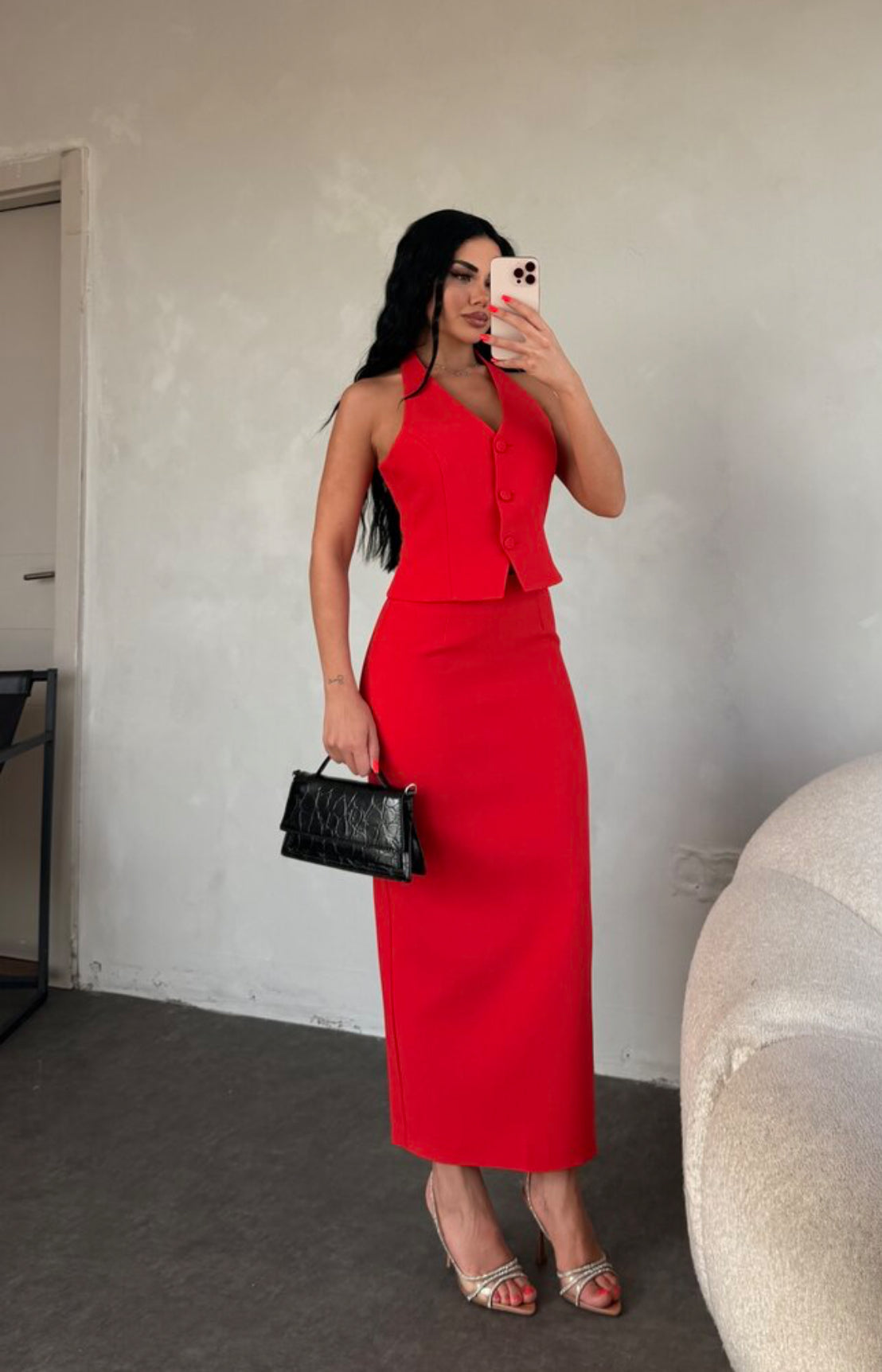 Set ZAIRA indossa un elegante completo bianco composto da un top senza maniche con bottoni e scollo a V, insieme a una gonna a matita lunga fino alla caviglia. Il tessuto di alta qualità