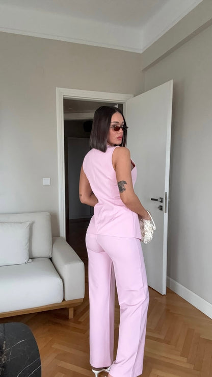 Tailleur ESTER elegante composto da un gilet smanicato e un paio di pantaloni a gamba larga  Il gilet presenta due bottoni decorativi centrali dal design gioiello. I pantaloni sono a vita alta, con una vestibilità morbida e fluida