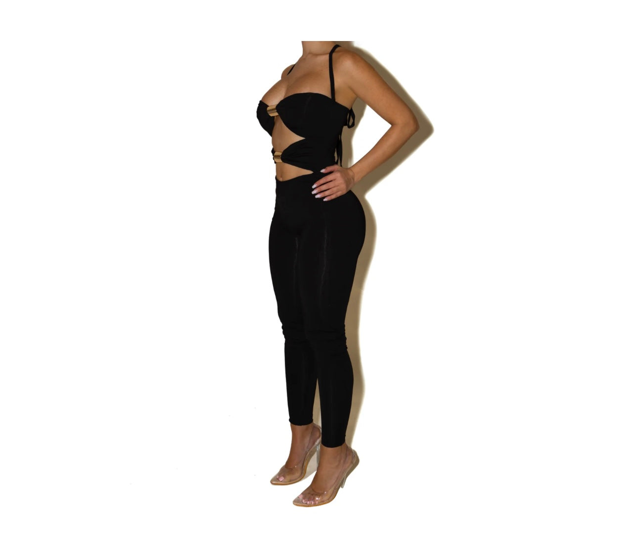 Jumpsuite SCARLETT Un look audace e raffinato che valorizza la silhouette con un design cut-out e dettagli metallici. Il top con inserti dorati e il pantalone a vita alta creano un equilibrio perfetto tra sensualità e stile moderno.