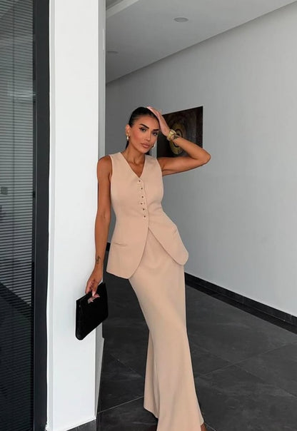 Tailleur ANTONELLA elegante in stile sartoriale è composto da un gilet senza maniche con scollo a V e chiusura a bottoni frontali. La gonna lunga e dritta si abbina perfettamente al gilet, creando un look sofisticato e minimalista