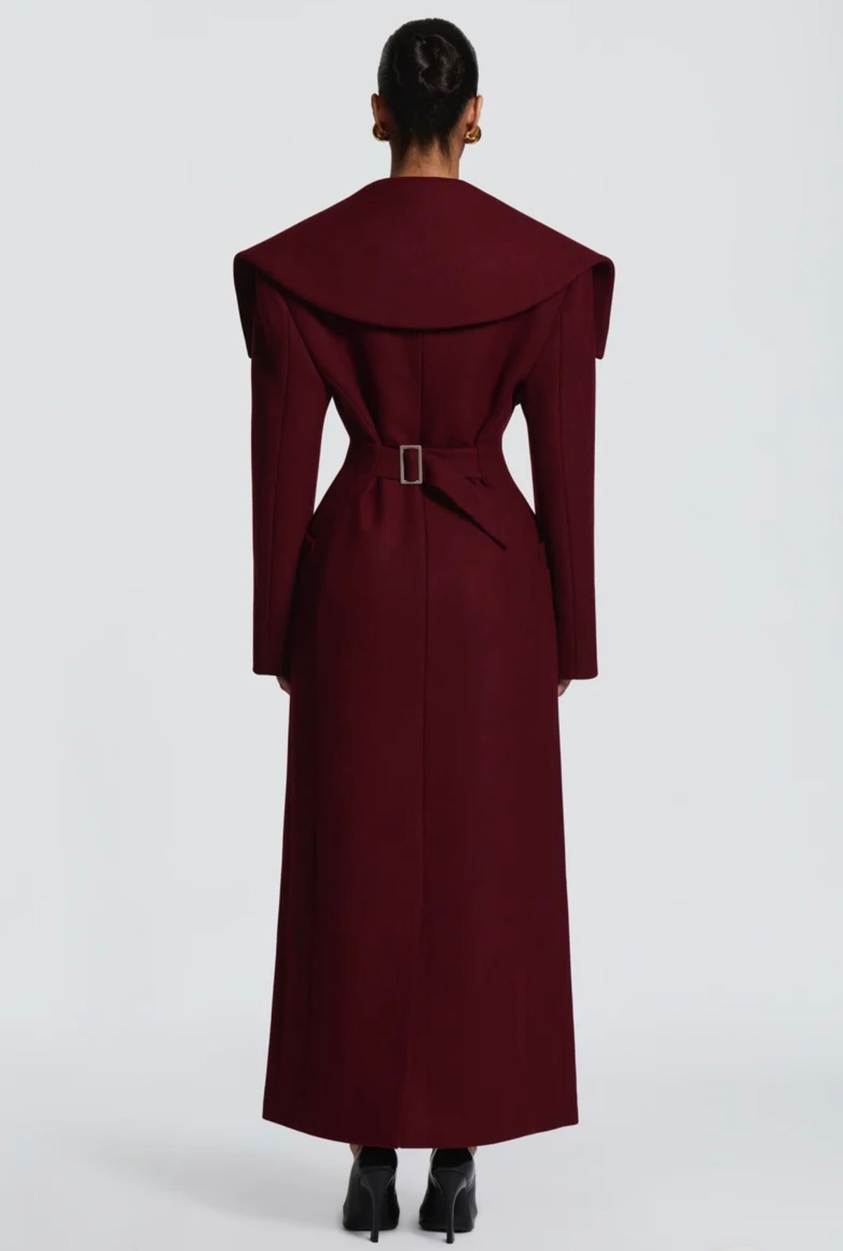 Cappotto Lungo Sartoriale con Maximantellina Un capospalla scenografico e di classe che ridefinisce l'eleganza invernale. Caratterizzato da un'ampia mantellina sulle spalle e una silhouette clessidra accentuata dal punto vita segnato.