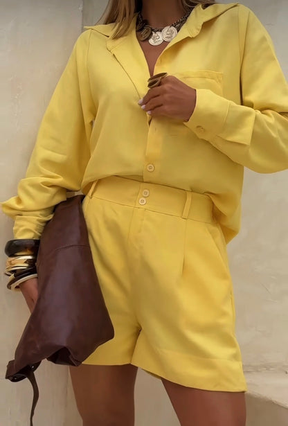 Coordinato Camilla camicia e shorts perfetto per la donna che ama uno stile curato anche nel tempo libero. Il coordinato
è composto da una camicia a maniche lunghe con colletto classico, taschino sul petto e bottoni centrali, abbinata a shorts sartoriali