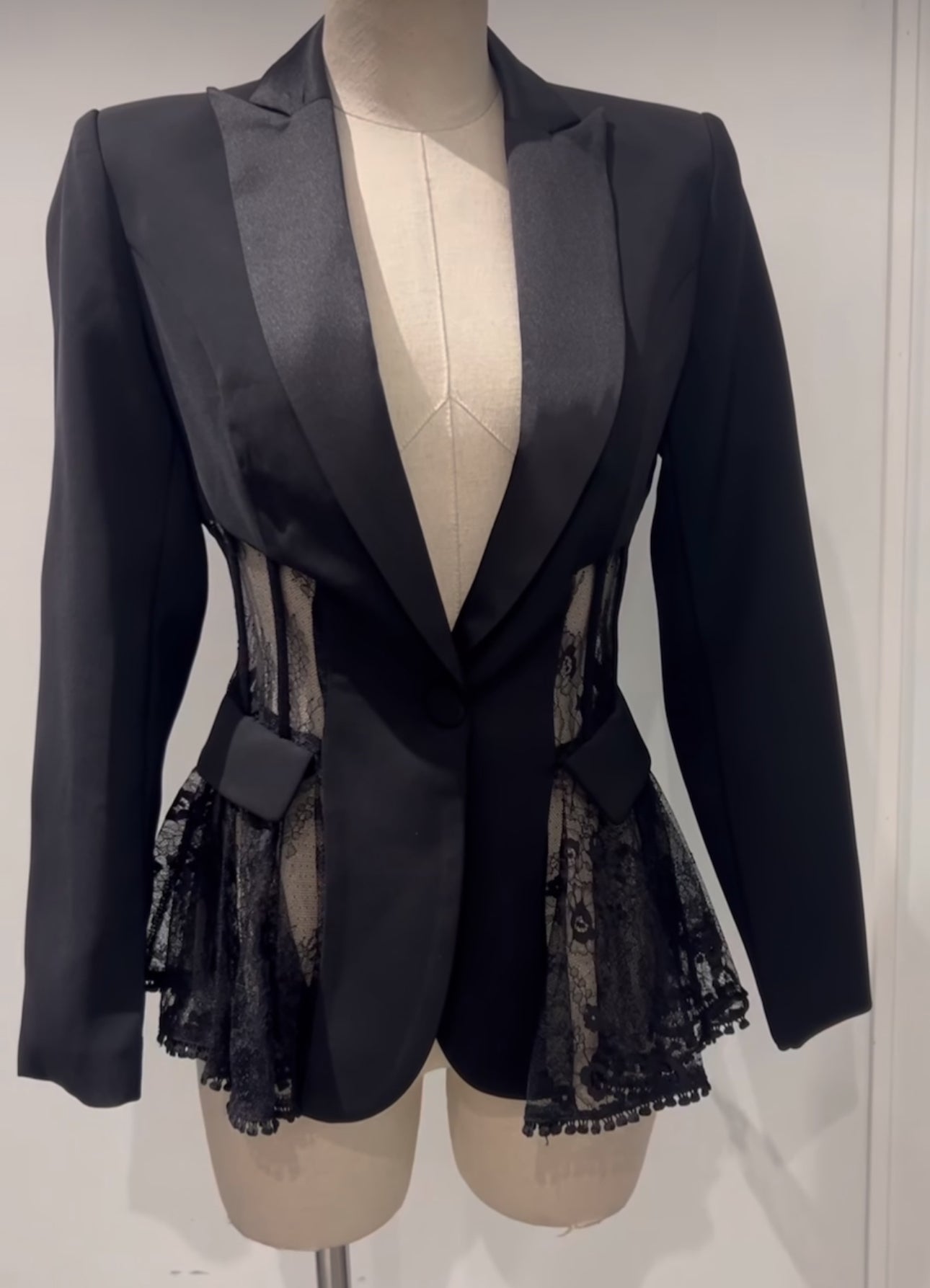 Tailleur MIA elegante composto da blazer e pantaloni coordinati, disponibile in quattro colori raffinati: nero, beige, rosa e azzurro. Il blazer presenta un elegante rever in raso e dettagli in pizzo trasparente sui lati pantalone classico