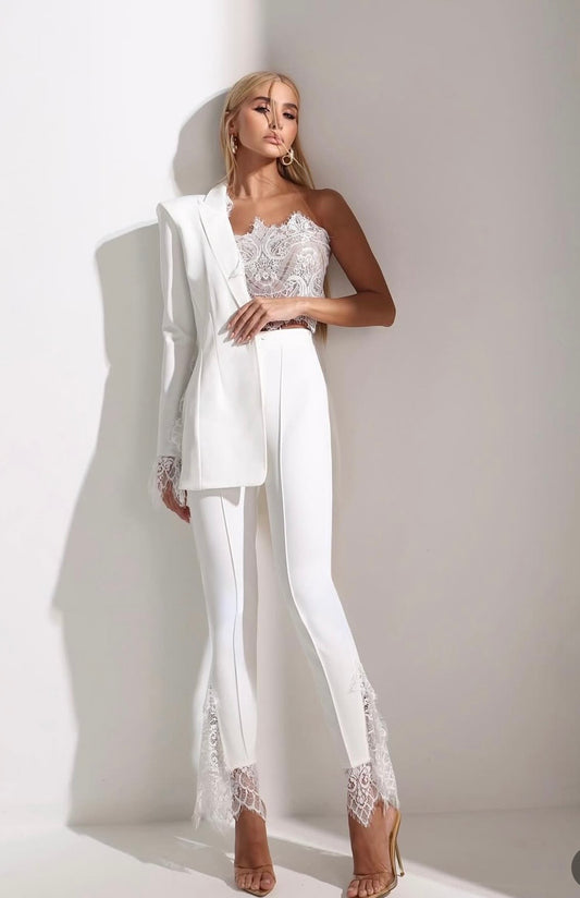 Tailleur Allys Tre Pezzi equilibrio perfetto: struttura e leggerezza in sintonia. I dettagli in pizzo chantilly sulle maniche del blazer e sulla barra dei pantaloni creano un gioco di texture sofisticate, mentre il top corsetto in pizzo e tulle
