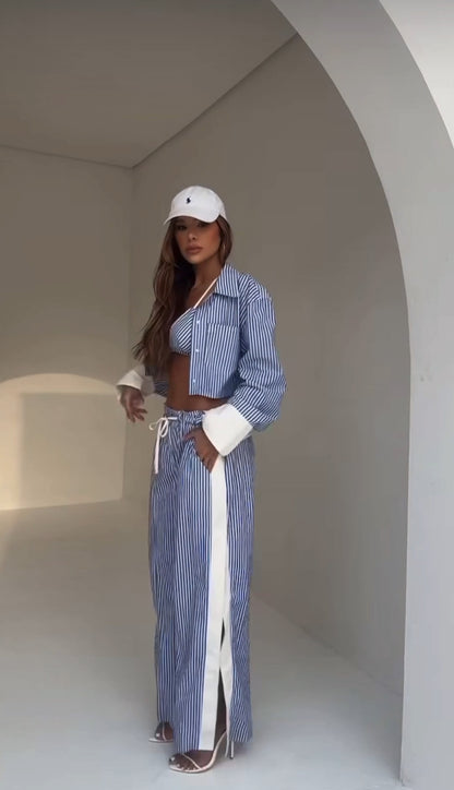 New Drop MARY questo completo in tessuto leggero a righe azzurre e bianche è composto da bralette, camicia oversize e pantaloni ampi con spacchi laterali. Realizzato in cotone misto, offre freschezza e comfort non fartelo scappare