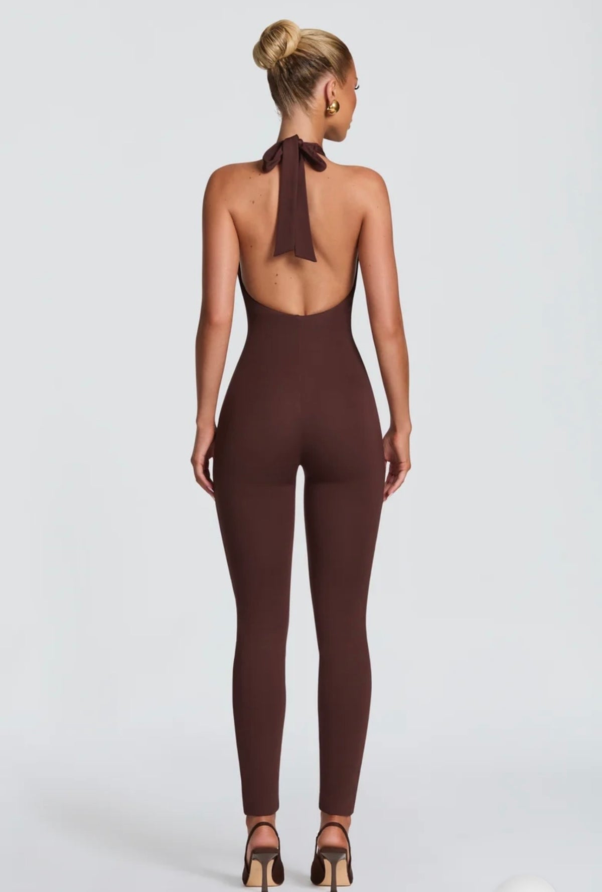 Tuta Intera Aderente Allacciata al Collo (Halter Jumpsuit) ultra-aderente con scollo all'americana e schiena scoperta. Un capo versatile e modellante che unisce eleganza minimale e sensualità, perfetto per serate ed eventi speciali.