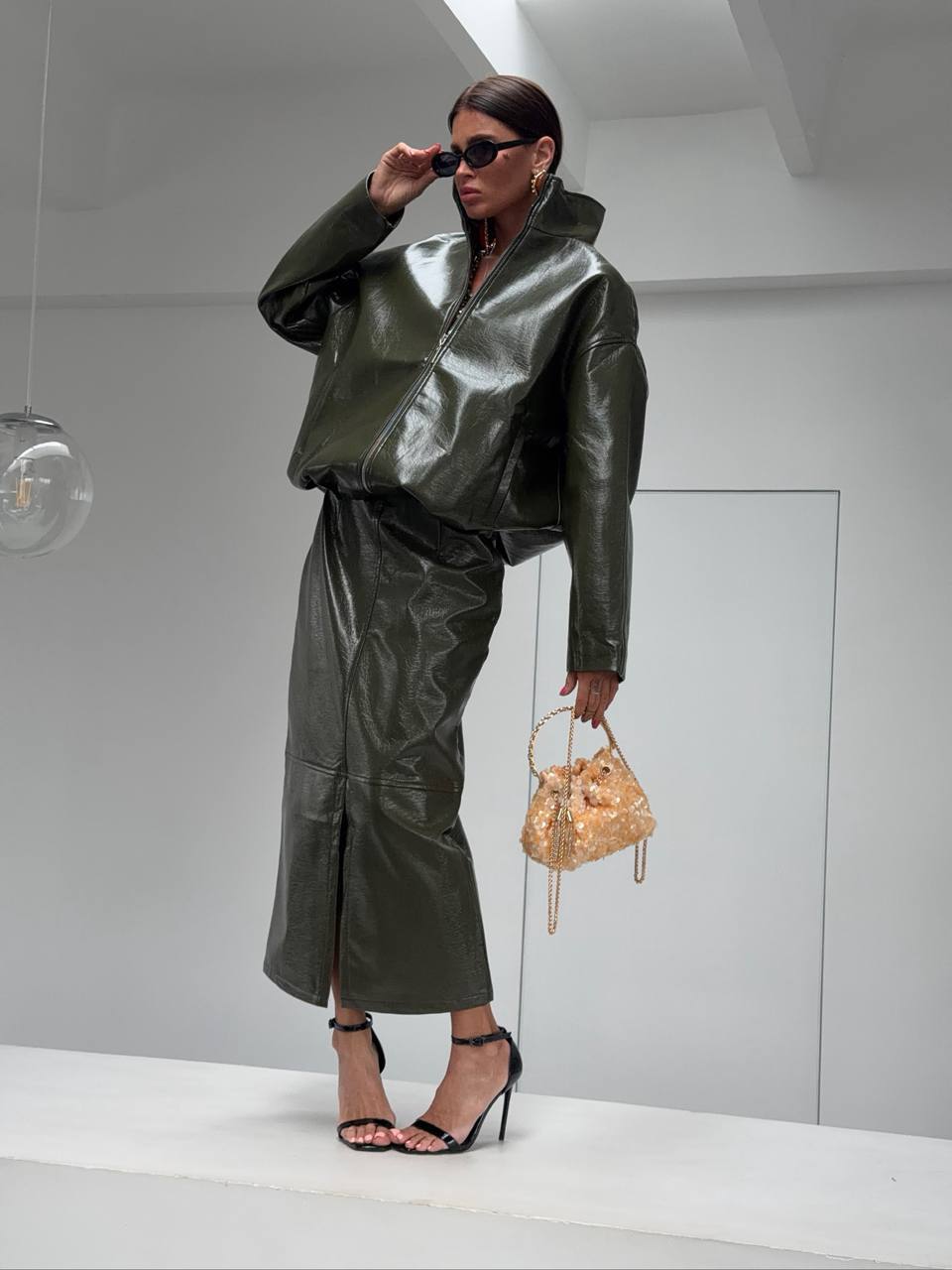 Co-ord Set in Similpelle Lucida Effect Noir
L'audacia incontra l'eleganza contemporanea. Eleva il tuo guardaroba con questo esclusivo coordinato a due pezzi, composto da una giacca bomber dallo stile urban-chic e una gonna midi dalla silhouette affusolata