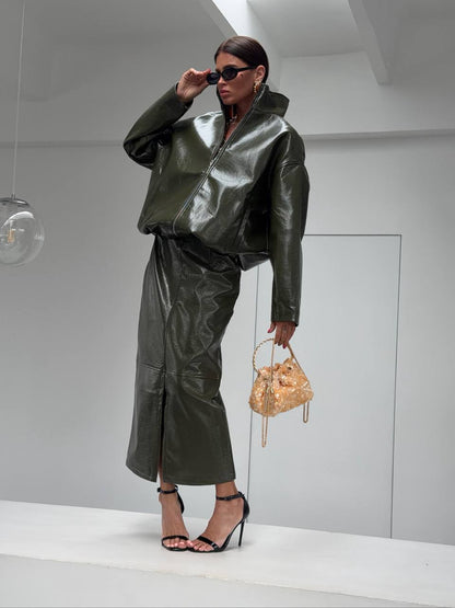 Co-ord Set in Similpelle Lucida Effect Noir
L'audacia incontra l'eleganza contemporanea. Eleva il tuo guardaroba con questo esclusivo coordinato a due pezzi, composto da una giacca bomber dallo stile urban-chic e una gonna midi dalla silhouette affusolata