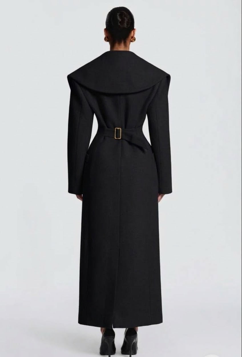 Cappotto Lungo Sartoriale con Maximantellina Un capospalla scenografico e di classe che ridefinisce l'eleganza invernale. Caratterizzato da un'ampia mantellina sulle spalle e una silhouette clessidra accentuata dal punto vita segnato.