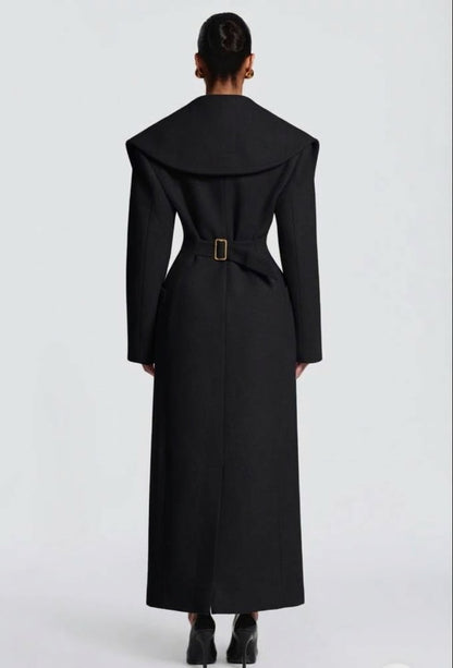 Cappotto Lungo Sartoriale con Maximantellina Un capospalla scenografico e di classe che ridefinisce l'eleganza invernale. Caratterizzato da un'ampia mantellina sulle spalle e una silhouette clessidra accentuata dal punto vita segnato.