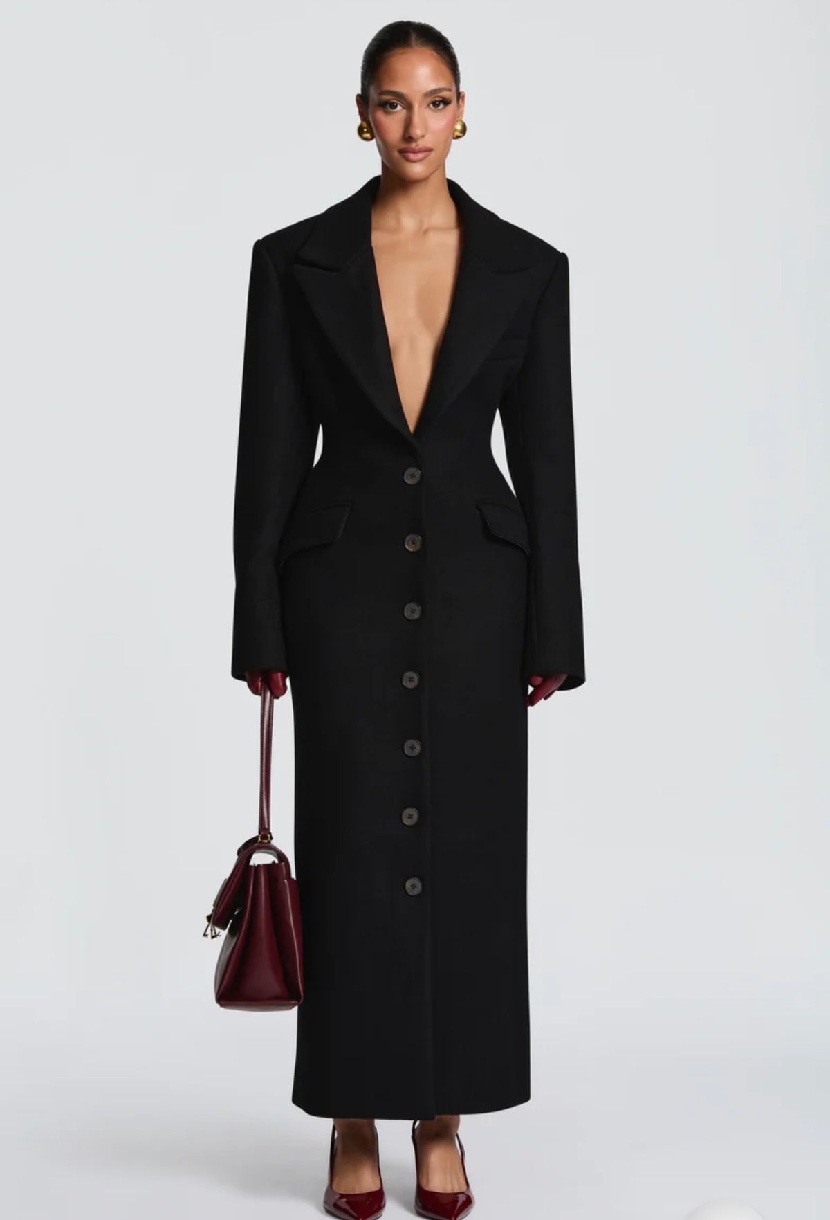 Cappotto ANGELICA lungo in lana, con bottoni frontali e maxi revers a scialle. La linea dritta e sartoriale slancia la figura, mentre il colletto ampio aggiunge un tocco sofisticato. Perfetto per look invernali raffinati, dal giorno alla sera.