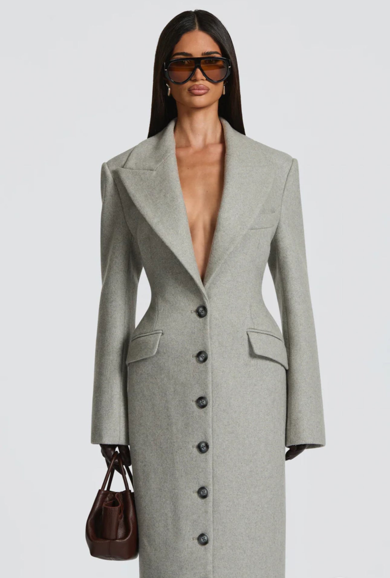 Cappotto ANGELICA lungo grigio in lana, con bottoni frontali e maxi revers a scialle. La linea dritta e sartoriale slancia la figura, mentre il colletto ampio aggiunge un tocco sofisticato. Perfetto per look invernali raffinati, dal giorno alla sera.