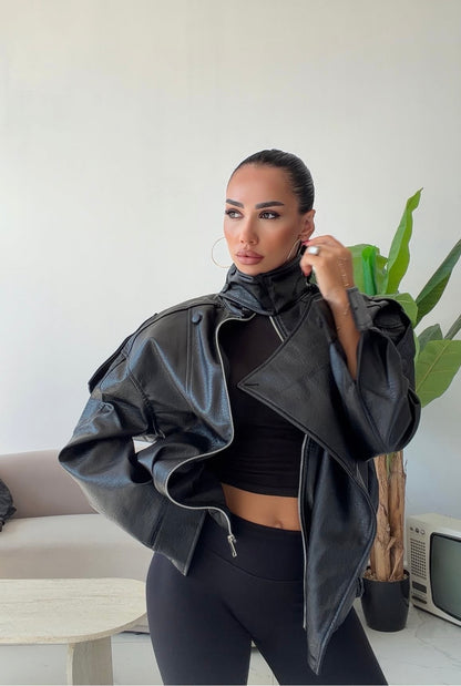 Giacca Biker Oversize in pelle Caratterizzata da una silhouette strutturata con spalle scese e un collo alto avvolgente con cinturino, è il capo spalla perfetto per completare i tuoi outfit streetwear ed eleganti con un tocco audace.