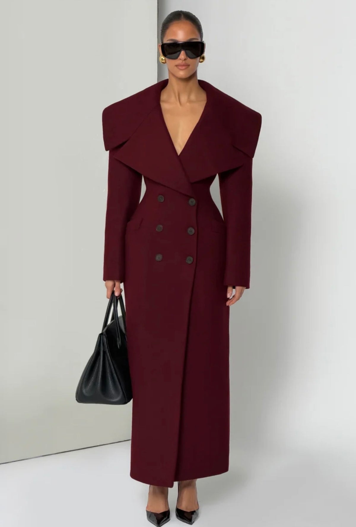 Cappotto Lungo Sartoriale con Maximantellina Un capospalla scenografico e di classe che ridefinisce l'eleganza invernale. Caratterizzato da un'ampia mantellina sulle spalle e una silhouette clessidra accentuata dal punto vita segnato.