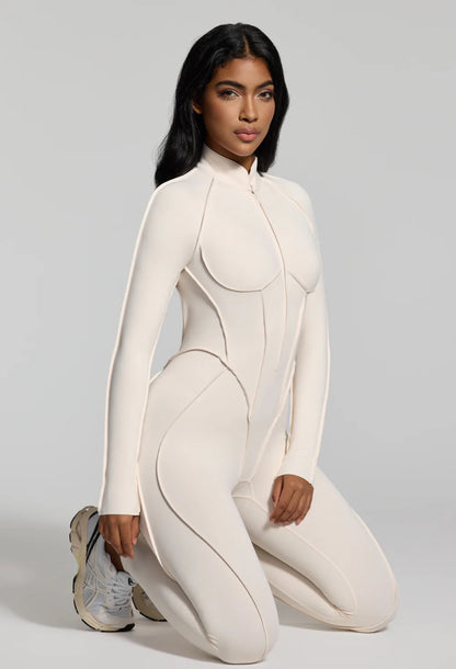 Jumpsuite EMY aderente con schiena scoperta, pensata per valorizzare la silhouette con un effetto shaping. Il tessuto elasticizzato ad alta compressione modella le forme