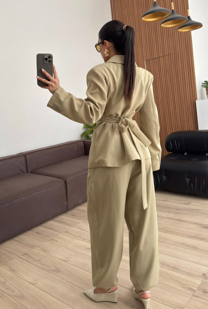 Tailleur Samantha”in promo” composto da giacca sartoriale con spalle strutturate e chiusura incrociata. La cintura integrata con bottoni decorativi stringe il punto vita valorizzando la silhouette e creando un elegante effetto corsetto l pantalone fluido