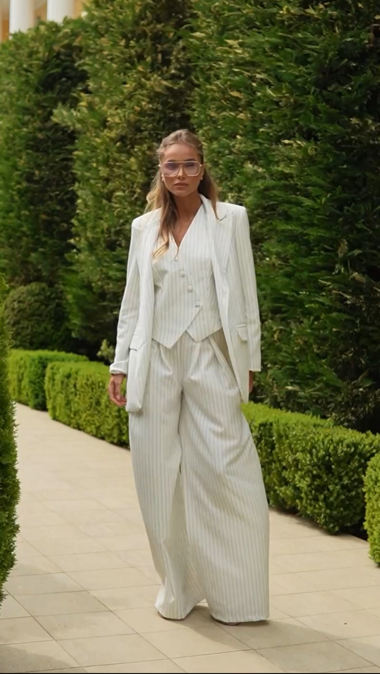 Tailleur VALERIA Blazer dal  taglio elegante e strutturato con spalle leggermente ampie, gilet con bottoni asimmetrici, pantaloni a vita alta con ampia vestibilità e pieghe, che creano un effetto fluido e raffinato.