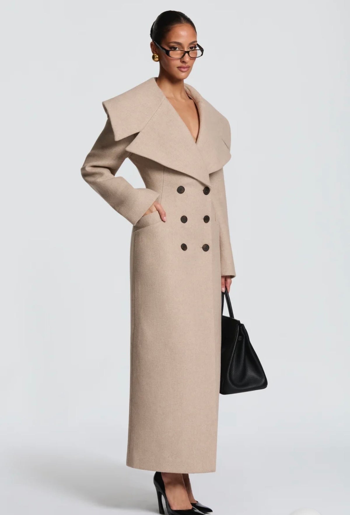 Cappotto Lungo Sartoriale con Maximantellina Un capospalla scenografico e di classe che ridefinisce l'eleganza invernale. Caratterizzato da un'ampia mantellina sulle spalle e una silhouette clessidra accentuata dal punto vita segnato.