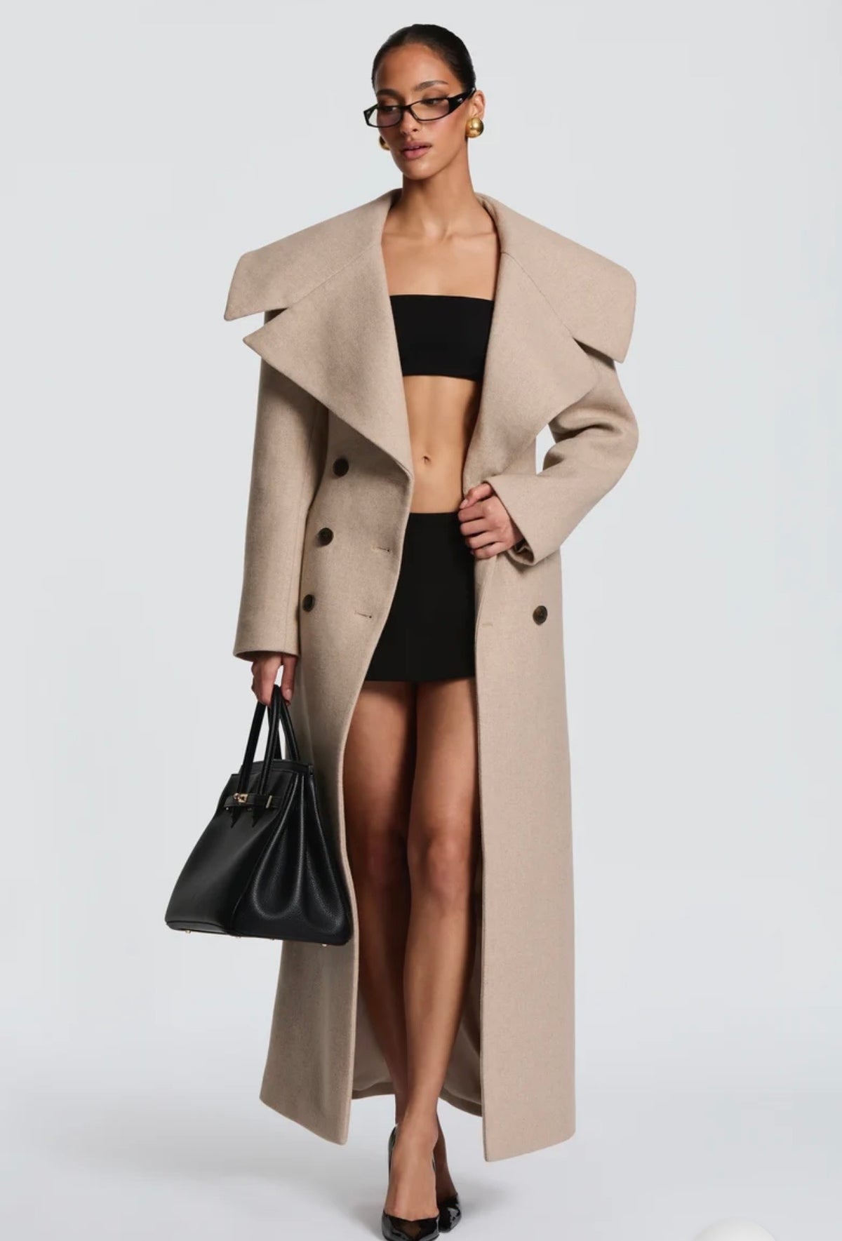 Cappotto Lungo Sartoriale con Maximantellina Un capospalla scenografico e di classe che ridefinisce l'eleganza invernale. Caratterizzato da un'ampia mantellina sulle spalle e una silhouette clessidra accentuata dal punto vita segnato.