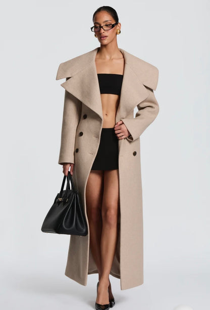 Cappotto Lungo Sartoriale con Maximantellina Un capospalla scenografico e di classe che ridefinisce l'eleganza invernale. Caratterizzato da un'ampia mantellina sulle spalle e una silhouette clessidra accentuata dal punto vita segnato.