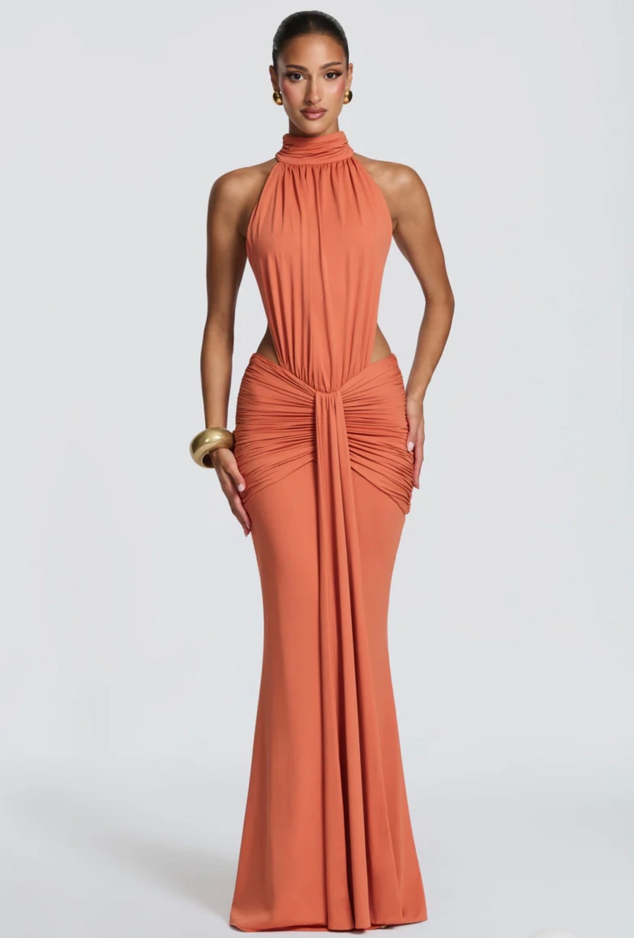 Abito Sofia Caratterizzato da una silhouette a sirena che valorizza le forme, questo modello unisce un sofisticato collo alto a un audace gioco di drappeggi e intagli cut-out sui fianchi.