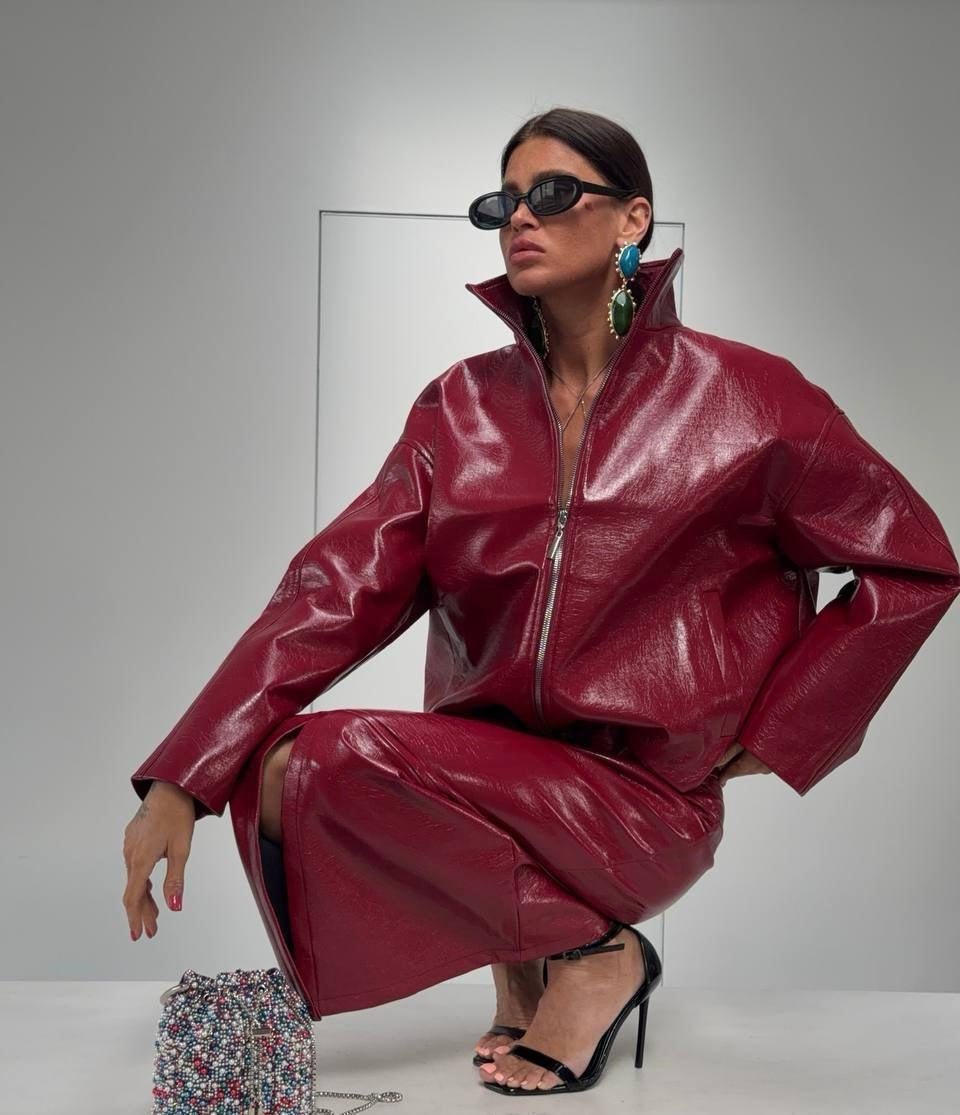 Co-ord Set in Similpelle Lucida Effect Noir
L'audacia incontra l'eleganza contemporanea. Eleva il tuo guardaroba con questo esclusivo coordinato a due pezzi, composto da una giacca bomber dallo stile urban-chic e una gonna midi dalla silhouette affusolata