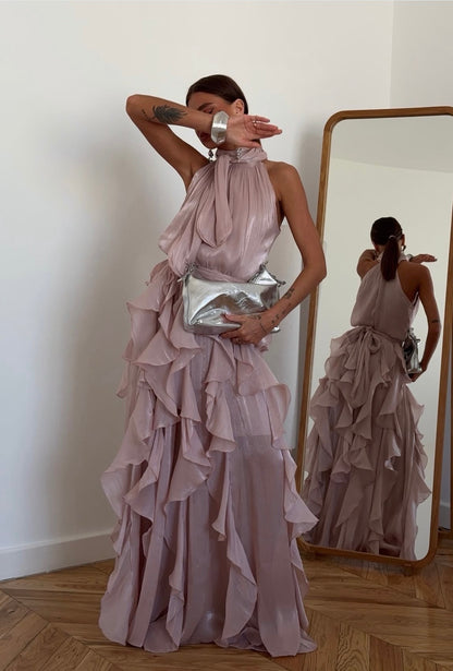 Abito Rouches maxi dress con scollo all'americana, collo con fiocco e gonna a cascata di rouches multistrato pensato per chi vuole essere al centro della scena senza sforzo. La silhouette fluida e il tessuto leggero lo rendono perfetto