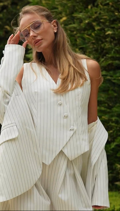 Tailleur VALERIA Blazer dal  taglio elegante e strutturato con spalle leggermente ampie, gilet con bottoni asimmetrici, pantaloni a vita alta con ampia vestibilità e pieghe, che creano un effetto fluido e raffinato.