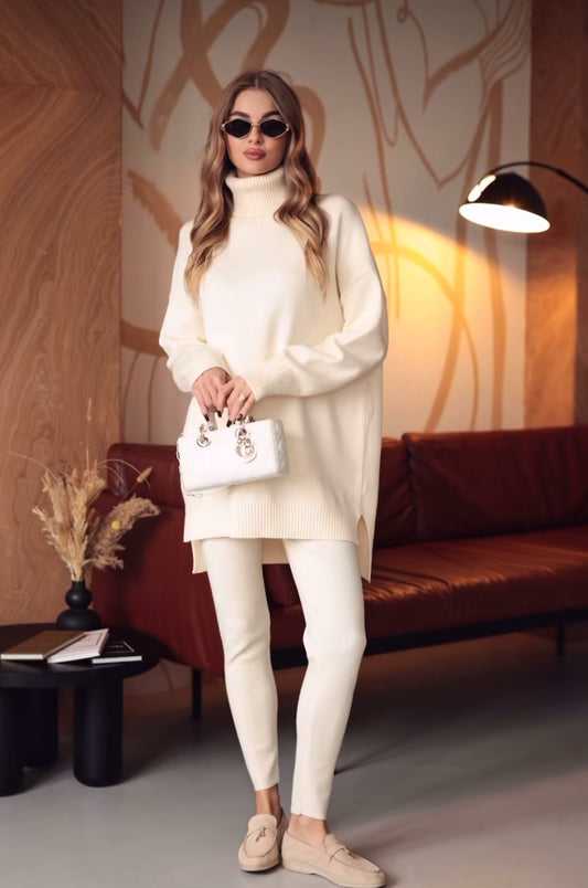 Coordinato ALBA indossa un coordinato in stile minimal e raffinato.
L'outfit è composto da un maxi maglione a collo alto in maglia con un design oversize e spacchetti laterali. È abbinato a pantaloni slim fit in coordinato