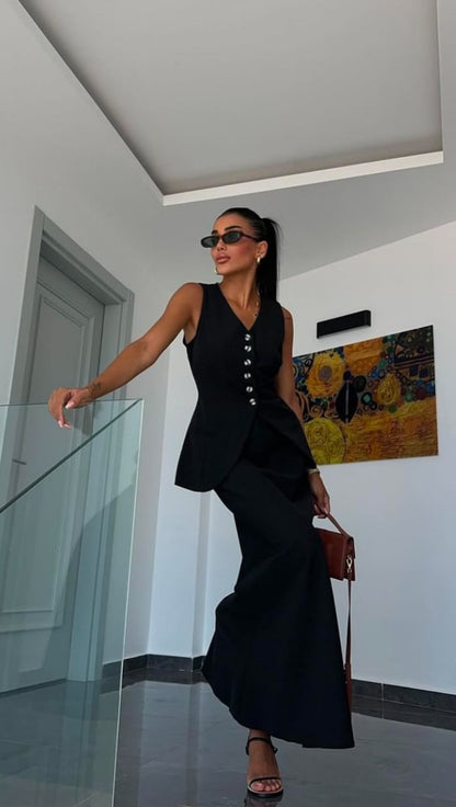Tailleur ANTONELLA elegante in stile sartoriale è composto da un gilet senza maniche con scollo a V e chiusura a bottoni frontali. La gonna lunga e dritta si abbina perfettamente al gilet, creando un look sofisticato e minimalista