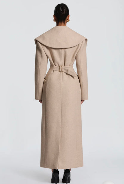Cappotto Lungo Sartoriale con Maximantellina Un capospalla scenografico e di classe che ridefinisce l'eleganza invernale. Caratterizzato da un'ampia mantellina sulle spalle e una silhouette clessidra accentuata dal punto vita segnato.