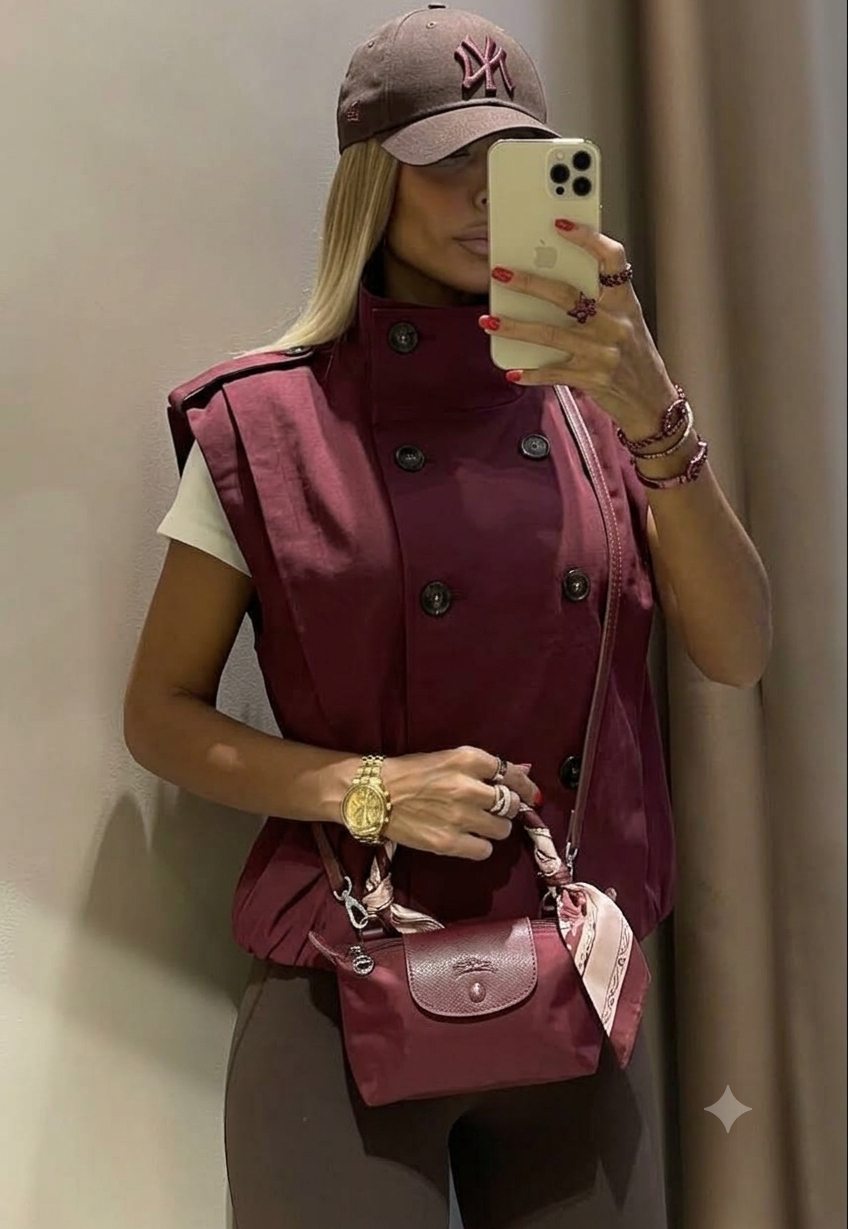 Gilet Trench Smanicato con Collo Alto Sartorialità e stile contemporaneo si fondono in questo gilet smanicato in stile trench. Caratterizzato da un design a doppio petto e un colletto alto strutturato