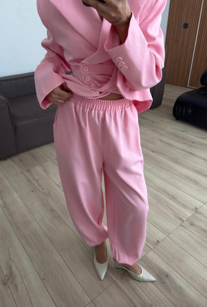 Tailleur Samantha”in promo” composto da giacca sartoriale con spalle strutturate e chiusura incrociata. La cintura integrata con bottoni decorativi stringe il punto vita valorizzando la silhouette e creando un elegante effetto corsetto l pantalone fluido