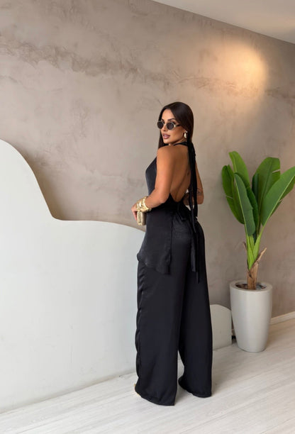 Coordinato Barbara Il set è composto di seta satinata da un top con scollo a cappuccio e schiena scoperta che valorizza la silhouette, abbinato a un pantalone a palazzo fluido che slancia la figura ad ogni passo.