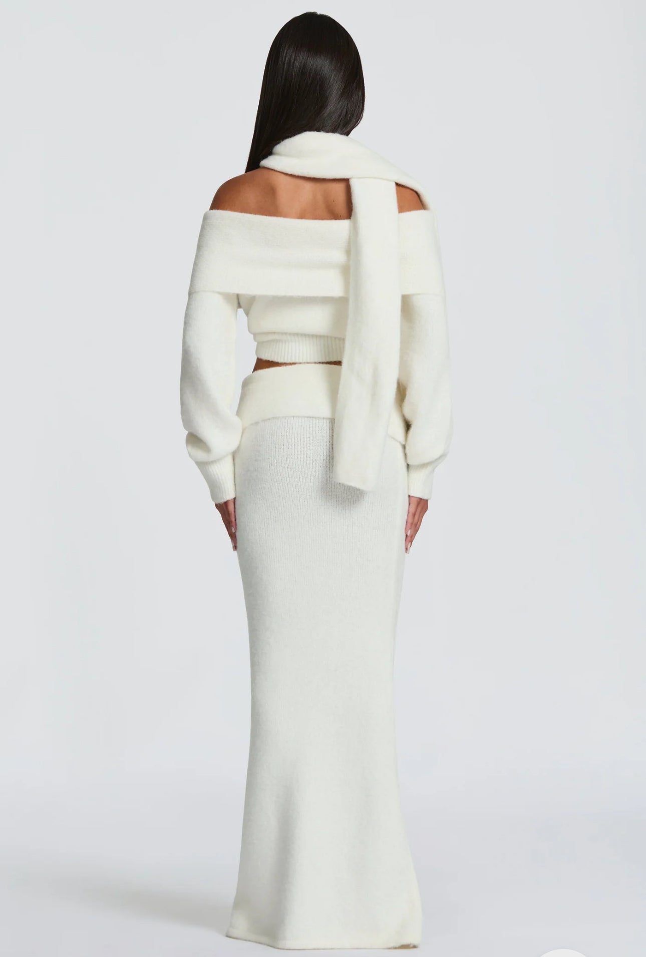 Set BIANCA composto da maglia off-shoulder e gonna lunga a sirena. Realizzato in morbida maglia calda, avvolge la silhouette con eleganza e comfort. Il design con collo ad anello e spalle scoperte aggiunge un tocco sofisticato e sensuale