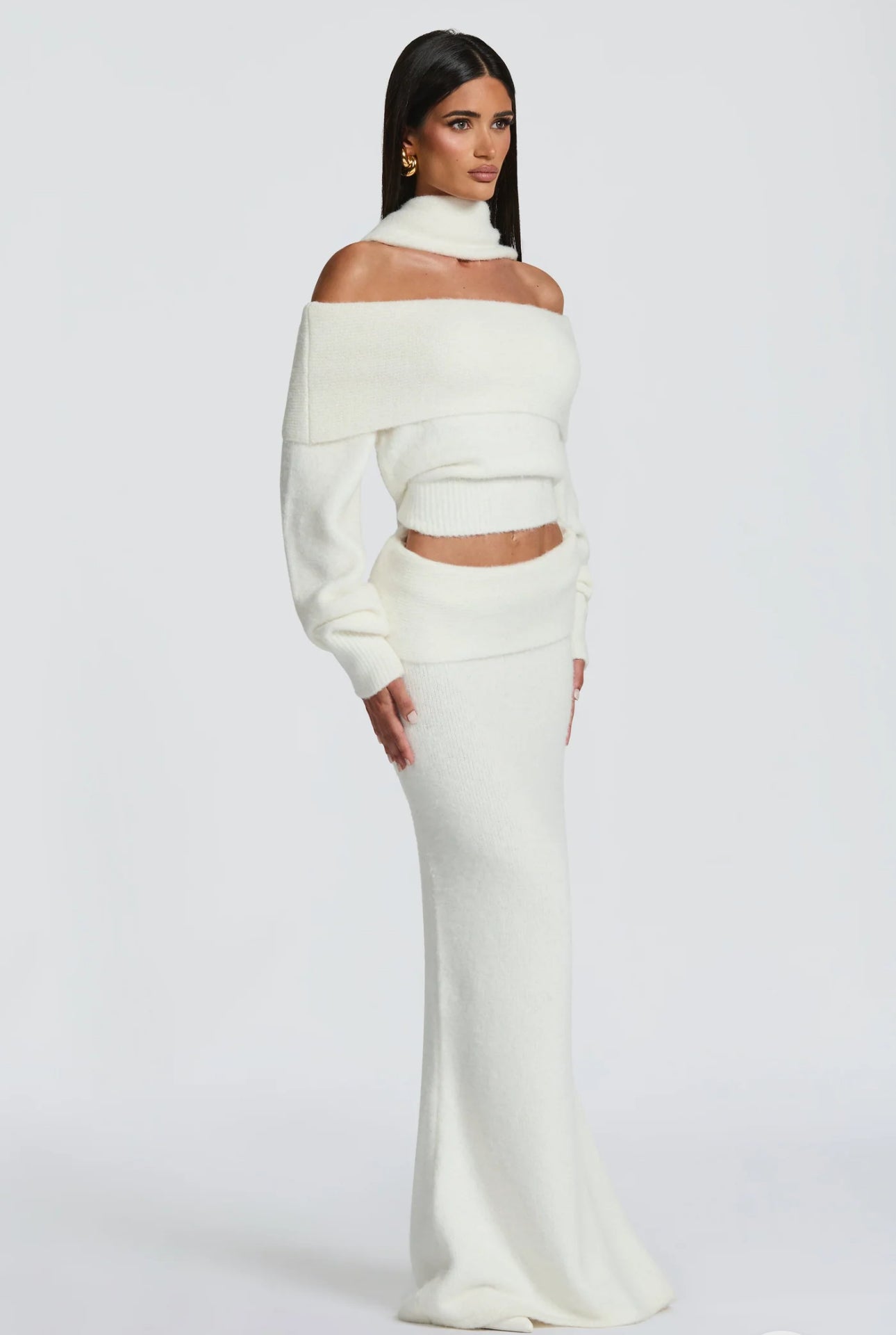Set BIANCA composto da maglia off-shoulder e gonna lunga a sirena. Realizzato in morbida maglia calda, avvolge la silhouette con eleganza e comfort. Il design con collo ad anello e spalle scoperte aggiunge un tocco sofisticato e sensuale