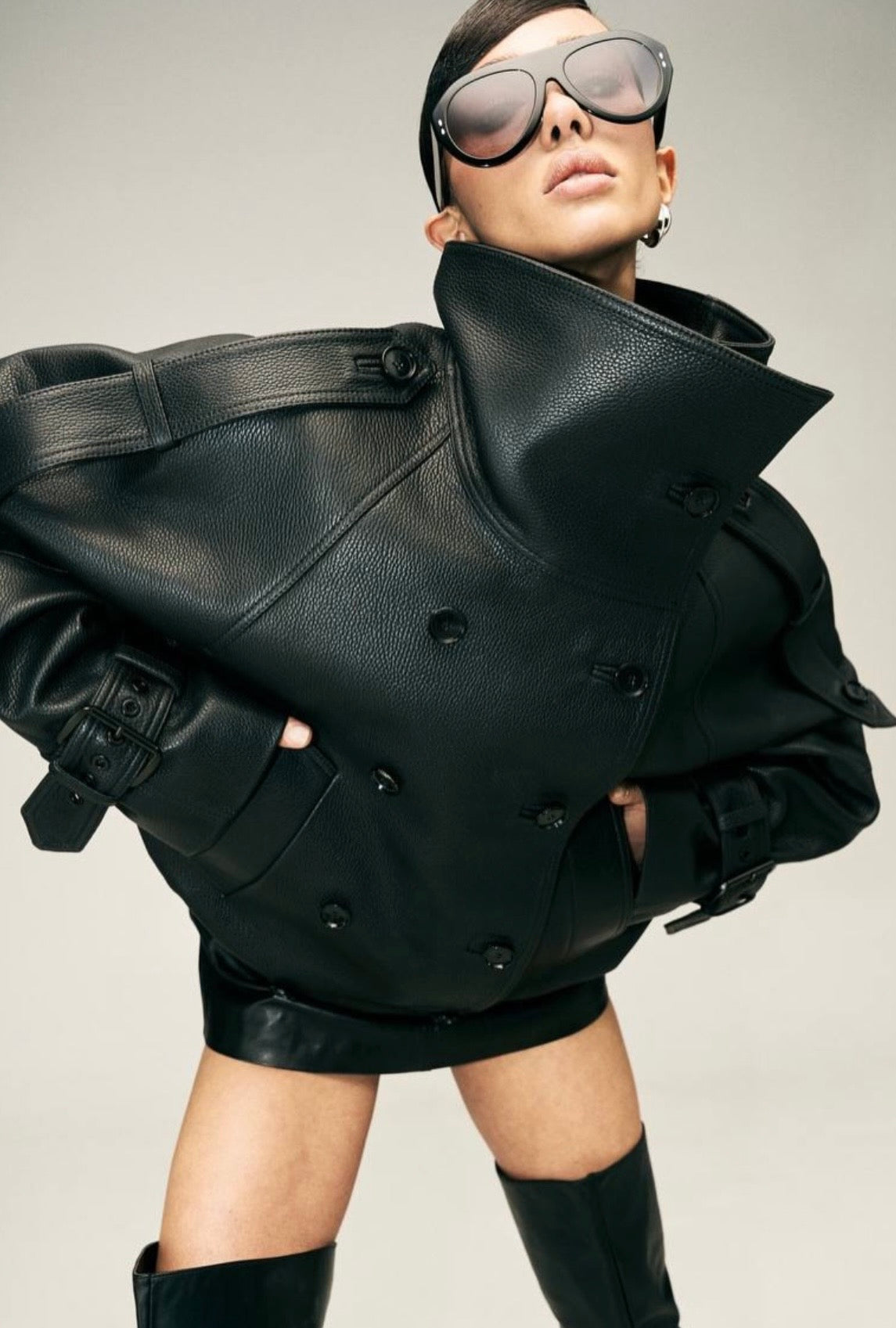 Eleva il tuo stile urbano con questo iconico giubbotto biker bomber oversize. Un capo che fonde la grinta della giacca in pelle al design d'avanguardia: caratterizzato da un imponente collo alto strutturato, allacciatura al petto