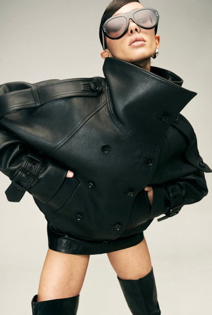Eleva il tuo stile urbano con questo iconico giubbotto biker bomber oversize. Un capo che fonde la grinta della giacca in pelle al design d'avanguardia: caratterizzato da un imponente collo alto strutturato, allacciatura al petto