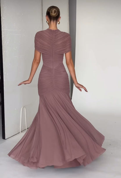 Abito Martina lungo elegante realizzato in tessuto leggero e drappeggiato che valorizza la silhouette. Design sofisticato con top incrociato effetto cut-out e gonna fluida a sirena.