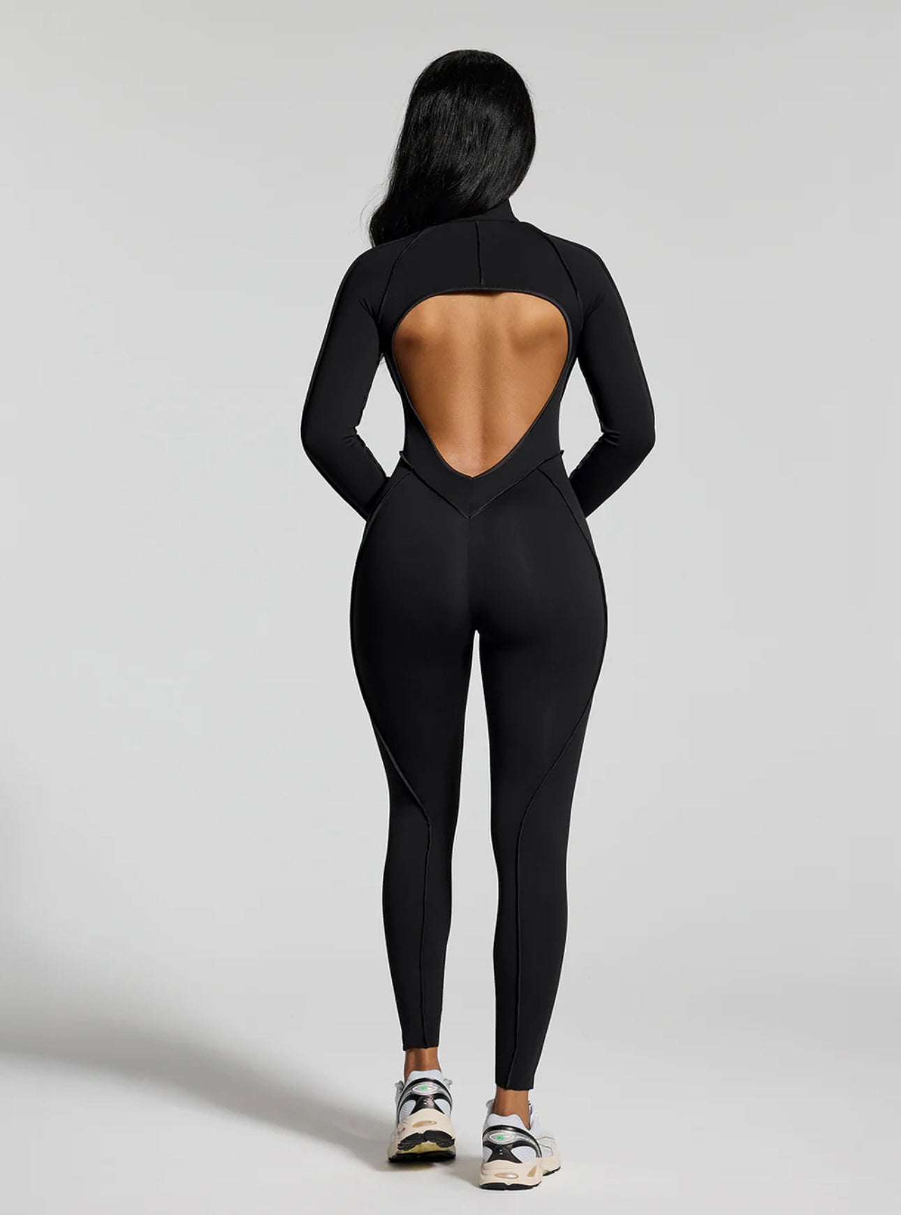 Jumpsuite EMY aderente con schiena scoperta, pensata per valorizzare la silhouette con un effetto shaping. Il tessuto elasticizzato ad alta compressione modella le forme