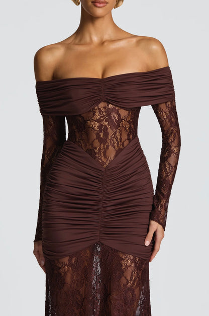 Abito AMIRA Elegante e sensuale, questo abito lungo off-shoulder in pizzo valorizza la silhouette con dettagli arricciati e trasparenze raffinate. Perfetto per cerimonie, eventi e serate glamour. Un look da vera protagonista.