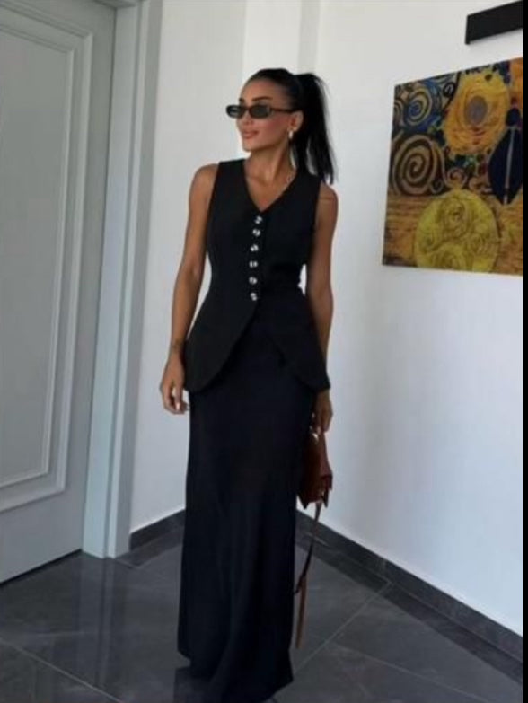Tailleur ANTONELLA elegante in stile sartoriale è composto da un gilet senza maniche con scollo a V e chiusura a bottoni frontali. La gonna lunga e dritta si abbina perfettamente al gilet, creando un look sofisticato e minimalista