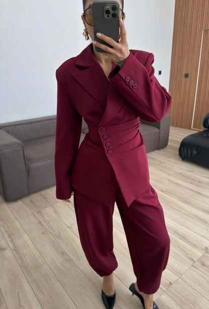 Tailleur Samantha”in promo” composto da giacca sartoriale con spalle strutturate e chiusura incrociata. La cintura integrata con bottoni decorativi stringe il punto vita valorizzando la silhouette e creando un elegante effetto corsetto l pantalone fluido