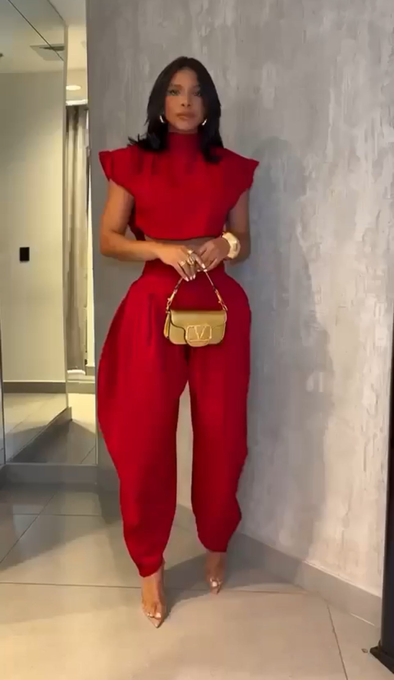 Set PRAGA Completo elegante composto da crop top a collo alto e pantaloni palazzo morbidi con pieghe frontali. Realizzato in tessuto fluido e leggero per una vestibilità confortevole e chic.