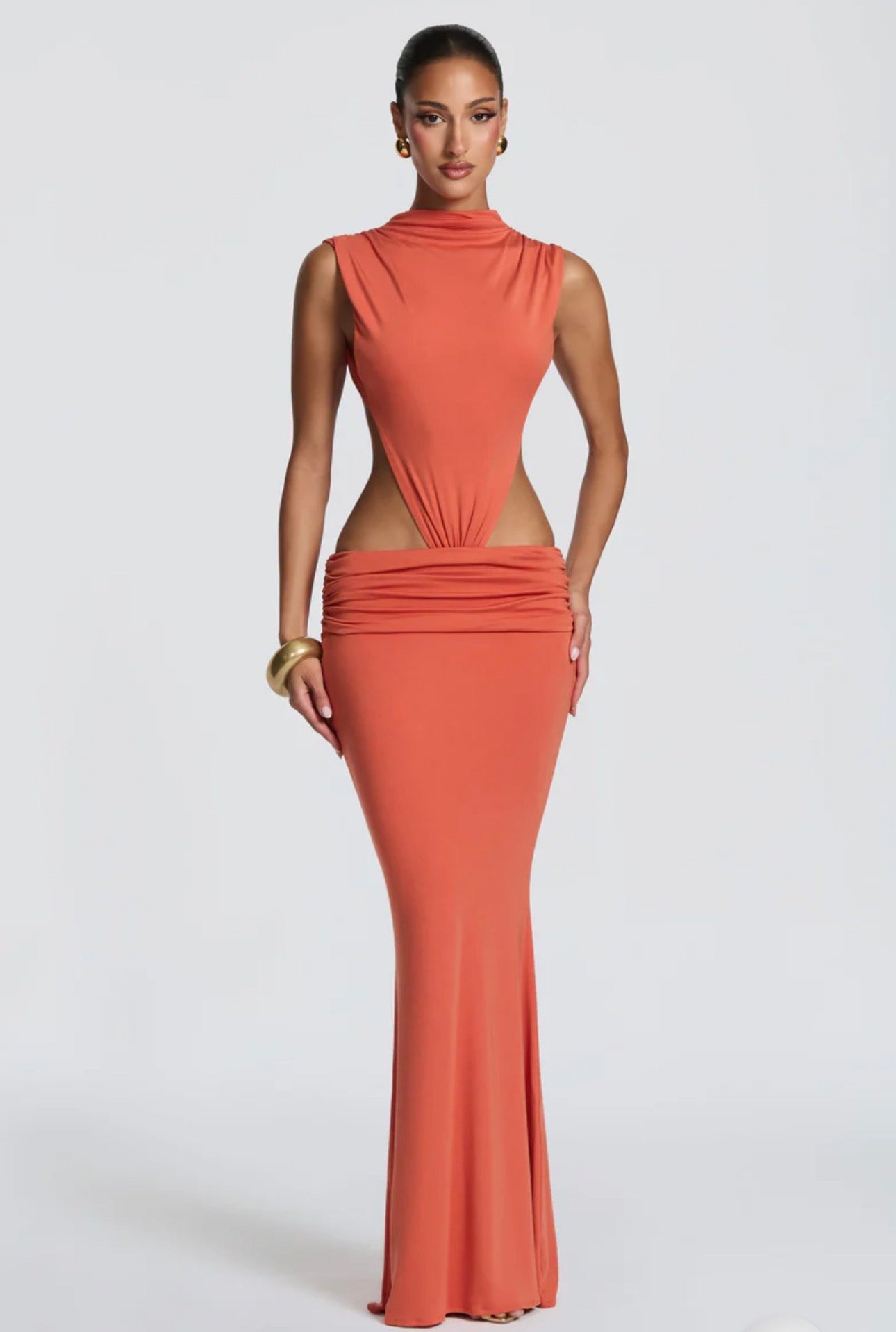 Abito Sahara maxi aderente  con design cut-out laterale che scolpisce la silhouette. Il collo alto crea un raffinato contrasto con le ampie aperture sui fianchi e la schiena scoperta, per un effetto sensuale ma sofisticato.
