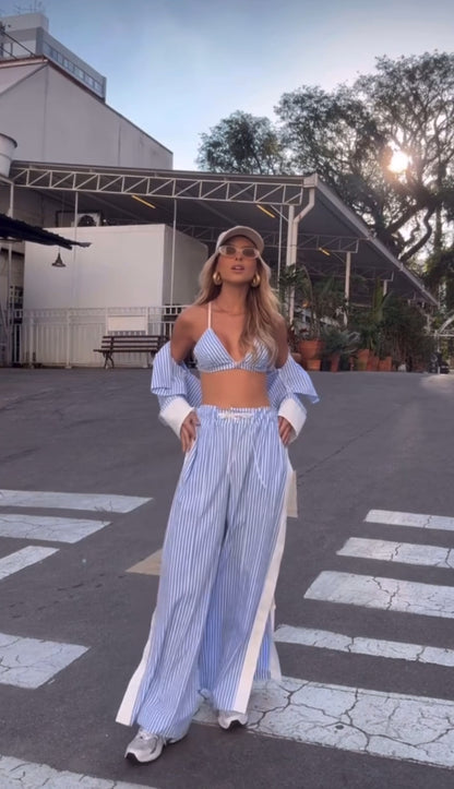 New Drop MARY questo completo in tessuto leggero a righe azzurre e bianche è composto da bralette, camicia oversize e pantaloni ampi con spacchi laterali. Realizzato in cotone misto, offre freschezza e comfort non fartelo scappare