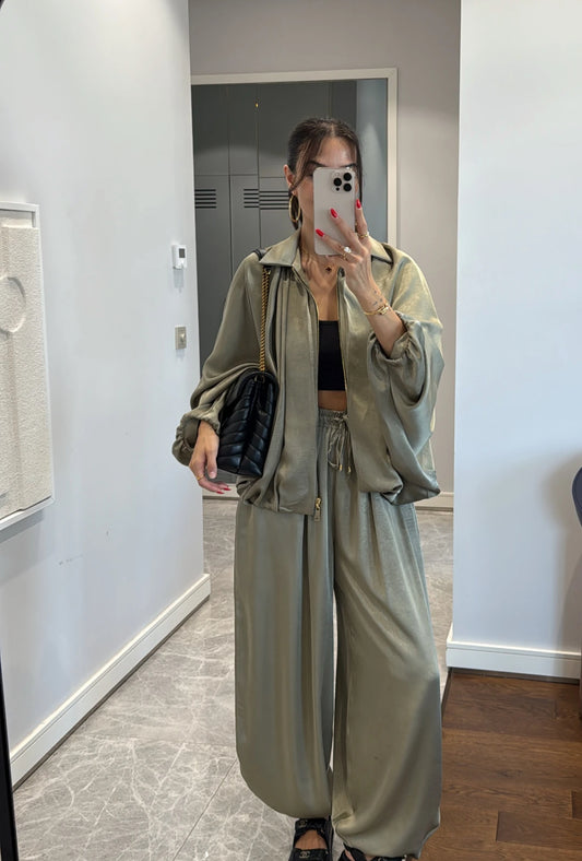 Coordinato PRISCILLA Completo elegante e versatile in tessuto satinato composto da giacca leggera oversize con zip e pantaloni ampi a vita alta con coulisse. Perfetto per look chic e confortevoli, dal giorno alla sera.